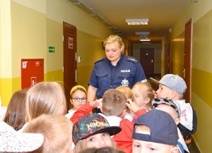 Korytarz komendy. Policjantka prowadzi grupę przedszkolaków na strzelnicę.