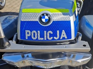 Klapa tylnego kufra motocykla z logiem marki BMW oraz białym napisem POLICJA na niebieskim tle.