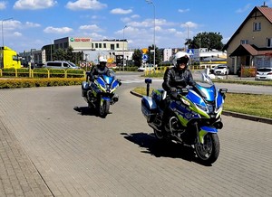 Dwa nowe policyjne motocykle w trakcie jazdy ulicą.