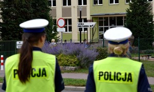 Policjantki stoją przy przejściu dla pieszych. W pobliżu widoczny budynek Szkoły Podstawowej nr 4 w Starogardzie Gd.