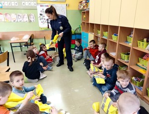 Zdęcie przedstawia policjantkę i uczniów w czasie prowadzonych zajęć.