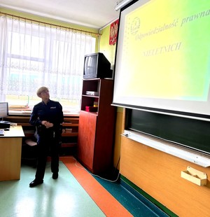 Policjantka w klasie szkolnej prowadzi zajęcia z uczniami.