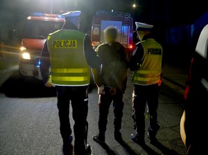 Policjanci z drogówki zatrzymali nietrzeźwego kierowcę. Mężczyzna ma założone kajdanki.