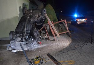 Na pierwszym planie rozbity samochód, a za nim widoczny budynek w który uderzył.