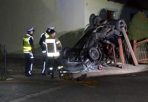 Służby pracują na miejscu zdarzenia. Widać rozbitego opla.