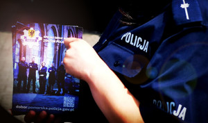 Policjantka trzyma ulotkę doborową.