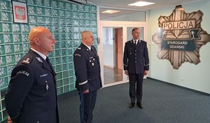 Zdjęcie grupowe. Komendant Wojewódzki, a po jego lewej i prawej stronie nowo powołani komendanci powiatowi. W tle na ścianie logo z policyjną gwiazdą.