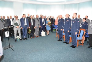 Aula KPP w Starogardzie Gdańskim. Uczestnicy uroczystości, policjanci oraz zaproszeni goście w pozycji stojącej.