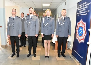 Stojący w szeregu policjanci oczekujący na komendę dotyczącą wystąpienia do wyróżnienia.