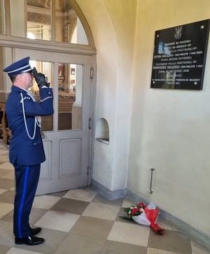 I Zastępca Komendanta w trakcie składania kwiatów przy tablicy upamiętniającej poległych policjantów.