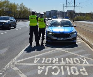 Policjanci na ulicy w trakcie prowadzenia kontroli prędkości.