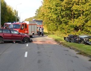 Policjanci pracują na miejscu wypadku. Funkcjonariusze w trakcie oględzin uszkodzonego auta.