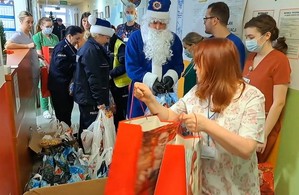 Policyjny Mikołaj w Kociewskim Centrum Zdrowia z dziećmi i personelem.