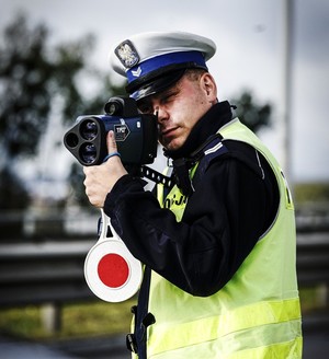 Policjant mierzy prędkość pojazdów.