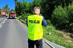 Technik kryminalistki zabezpiecza ślady na miejscu wypadku drogowego.