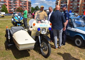 Zabytkowe pojazdy. Motocykl i mały fiat.