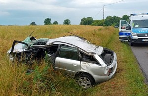 Radiowóz policyjny i rozbite na poboczu audi.