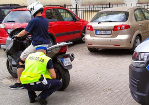 Policjant kontroluje stan techniczny motocykla.