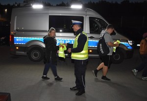 Policjanci wręczają elementy odblaskowe.