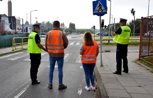 Policjanci i przedstawiciele Generalnej Dyrekcji Dróg Krajowych i Autostrad w trakcie kontrolowania oznakowania przejść dla pieszych w rejonach szkół usytuowanych przy drodze krajowej nr 22.