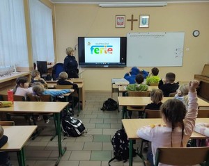 Policjantka prowadzi zajęcia z dziećmi.