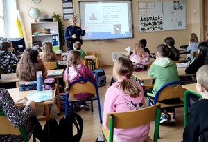 Policjantka prowadzi zajęcia z dziećmi.
