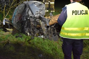 Zdjęcie z miejsca wypadku drogowego. Policjanci pracują na miejscu zdarzenia.