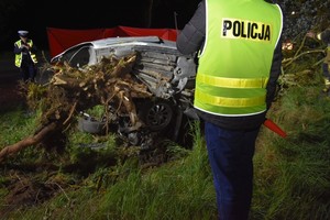 Zdjęcie z miejsca wypadku drogowego. Policjanci pracują na miejscu zdarzenia.