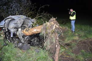 Zdjęcie z miejsca wypadku drogowego. Policjanci pracują na miejscu zdarzenia.