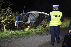 Zdjęcie z miejsca wypadku drogowego. Policjanci pracują na miejscu zdarzenia.