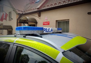 Kogut policyjnego radiowozu na tle budynku Posterunku Policji w Skórczu.