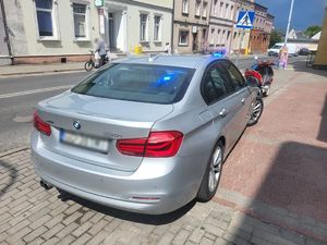 Policyjne bmw, a przed nim zaparkowany motocykl.