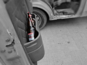 Butelki z alkoholem w schowku na drzwiach samochodu.