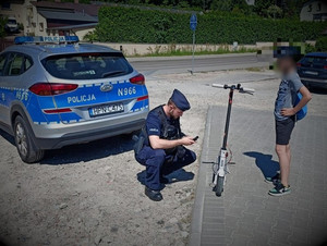 Policjant sprawdza hulajnogę.