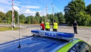 Policjanci z pracownikami PKP w czasie działań informacyjnych przy przejeździe kolejowym.