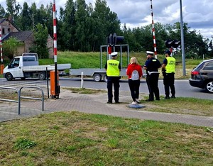 Policjanci z pracownikami PKP w czasie działań informacyjnych przy przejeździe kolejowym.