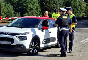 Policjanci z pracownikami PKP w czasie działań informacyjnych przy przejeździe kolejowym.
