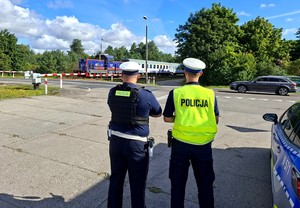 Policjanci z pracownikami PKP w czasie działań informacyjnych przy przejeździe kolejowym.