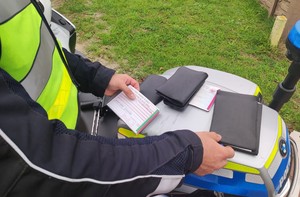 Policjant wypisuje mandat.