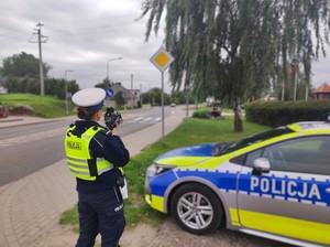 Policjantka mierzy prędkość jadących pojazdów.