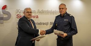 Komendant Wojewódzki Policji w Gdańsku nadinsp. Bogusław Ziemba z Dyrektorem Izby Administracji Skarbowej w Gdańsku Czesławem Kalinowskim na wspólnym zdjęciu przekazują sobie uścisk dłoni.