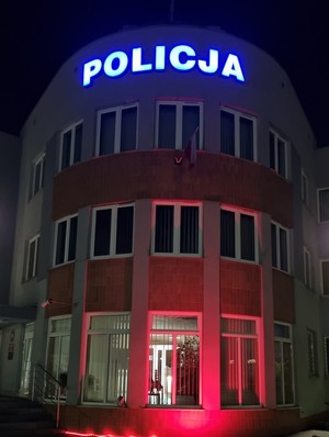 Zdjęcie frontu budynku Komendy Powiatowej Policji w Starogardzie Gdańskim podświetlonego na czerwono.