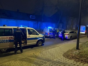 Policjanci w miejscu zatrzymania kierowcy hyundaia. Radiowozy z włączonymi światłami błyskowymi.