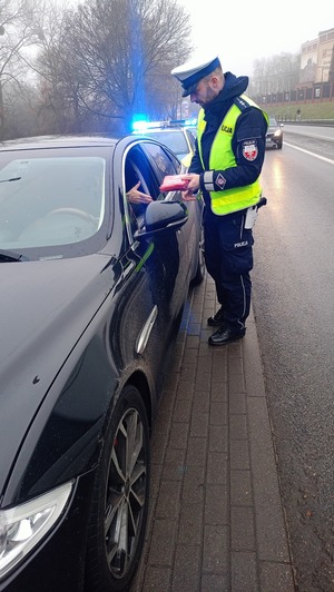 Policjant wręcza apteczkę.