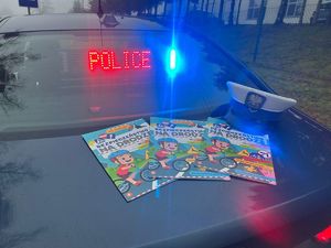 Policyjny radiowóz i rozłożone kolorowanki dla dzieci.