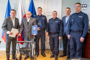 Zdjęcie grupowe, na którym jest policjant potrzebujący pomocy.