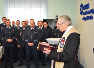 Kapelan przemawia wśród uczestników spotkania.