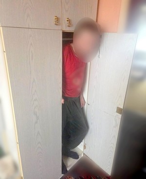 Mężczyzna z zablurowanym wizerunkiem wychodzi z szafy.