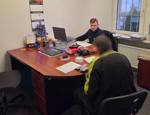 Policjant przesłuchuje podejrzanego mężczyznę.