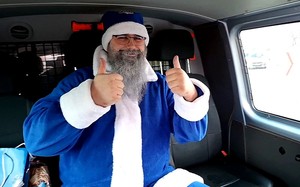 Niebieski Mikołaj trzyma kciuki uniesione do góry.